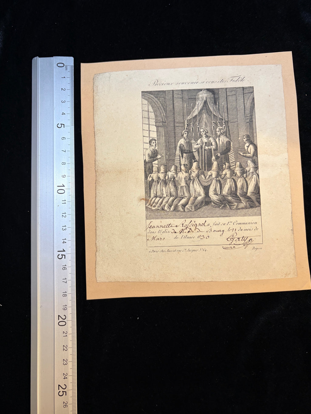 1830 First Communion certificate of Jeannette Rossignol next to a ruler showing its size, about 14.5 x 16.5 cm on a card mount