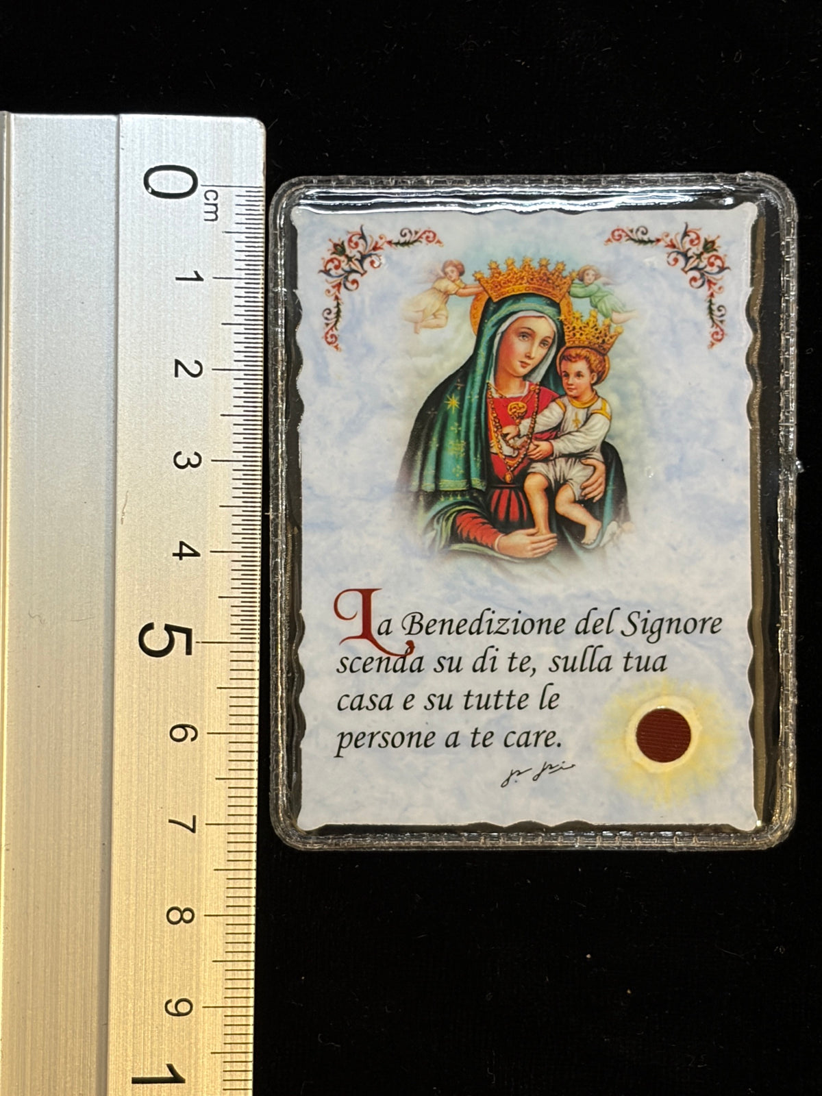 Padre Pio relic card next to a ruler showing its size, about 5.8 x 7.4 cm