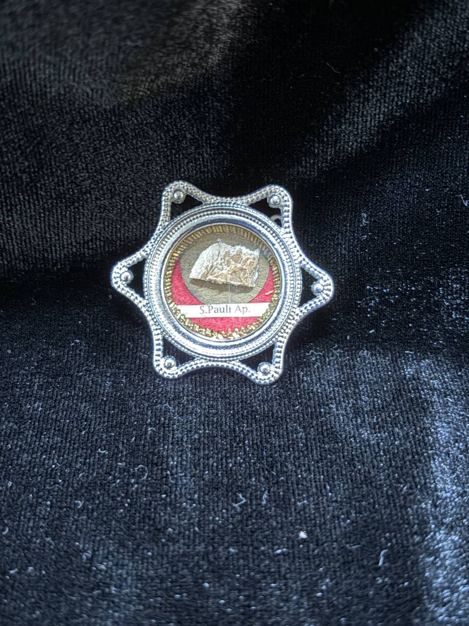 Saint Paul the Apostle relic in a silver star-shaped theca, label S. Pauli Ap., on black velvet