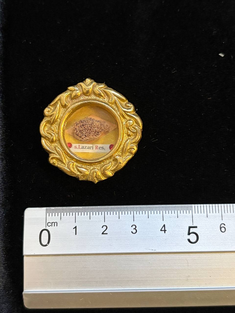 Saint Lazarus relic gilt theca next to a ruler, about 4 cm across