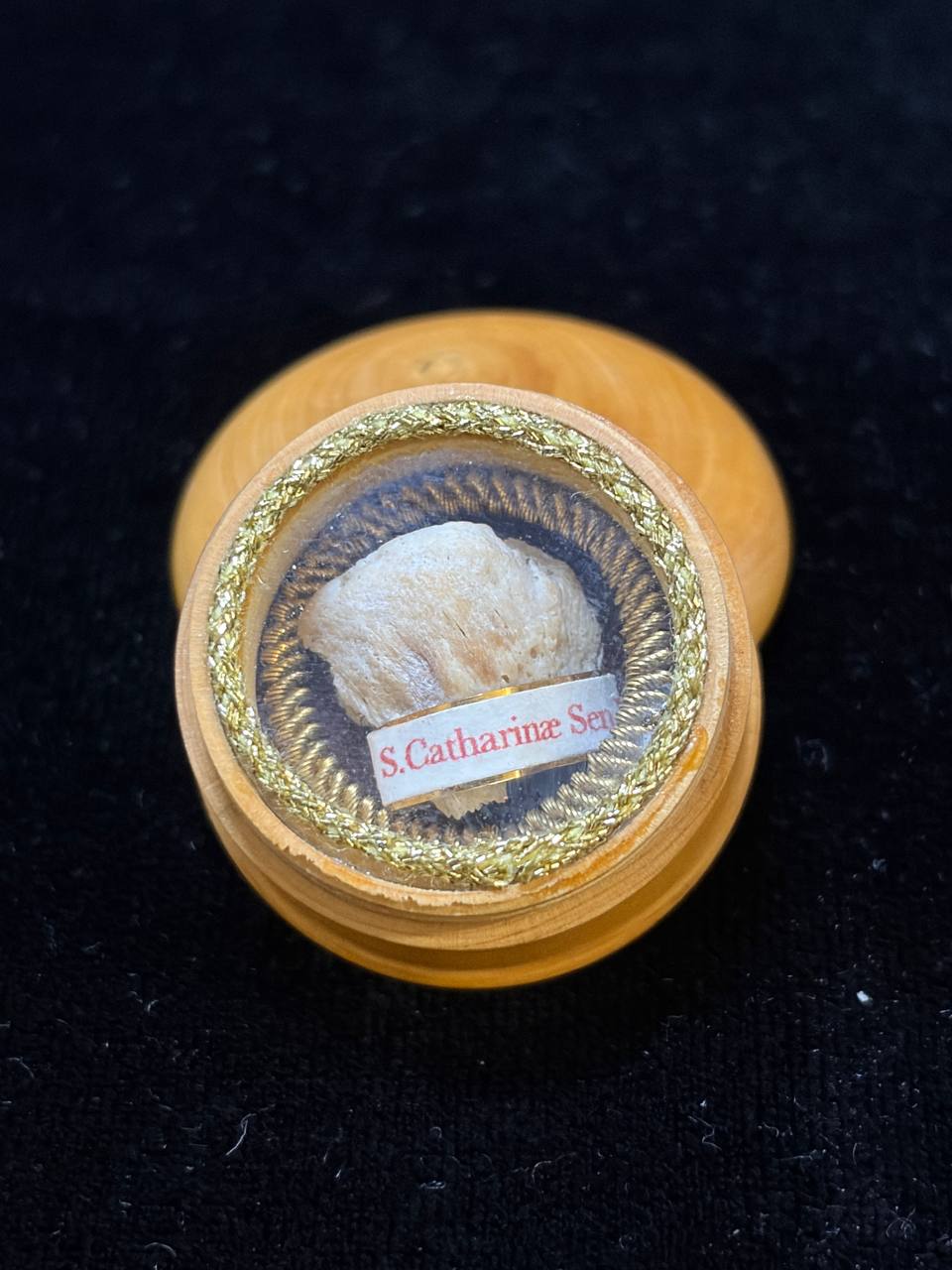 Saint Catherine of Siena relic in a round turned wooden theca with gilt rim, label S. Catharinae Sen., close-up