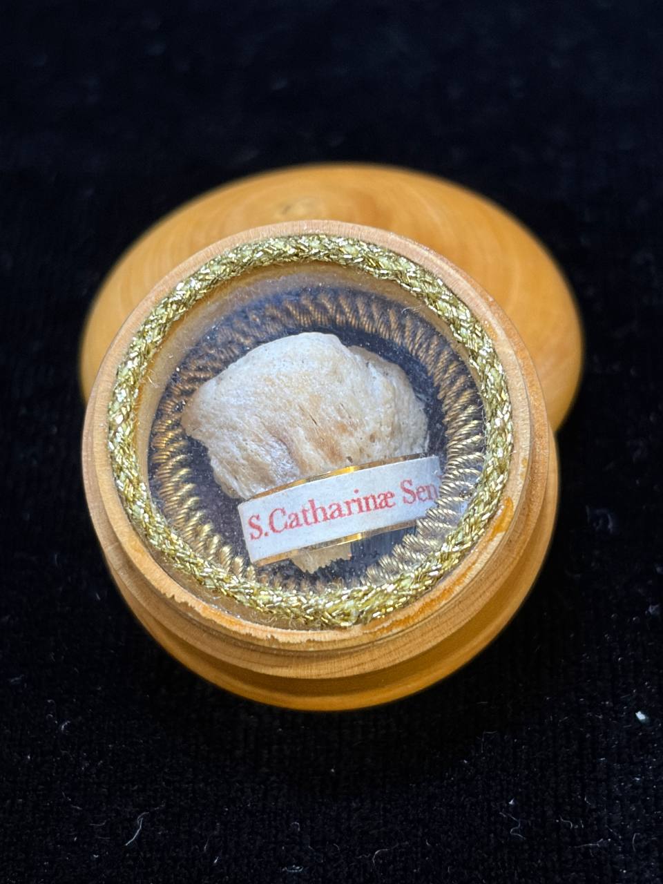 Saint Catherine of Siena relic in a round turned wooden theca with gilt rim, label S. Catharinae Sen., front view