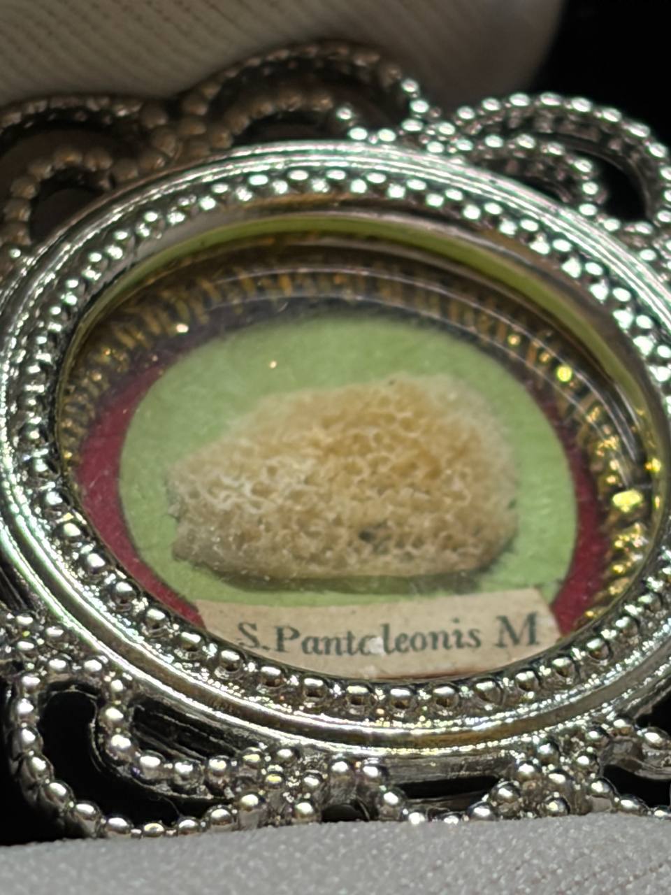 Saint Pantaleon relic in a silver filigree theca, label S. Pantaleonis M., macro detail of the bone relic