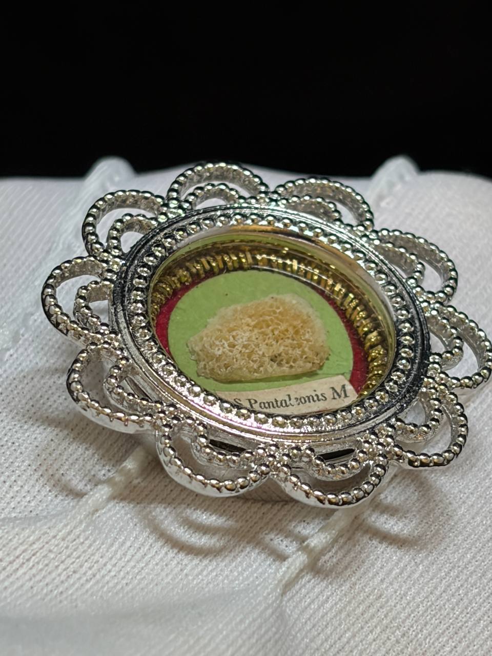 Saint Pantaleon relic in a silver filigree theca, label S. Pantaleonis M., resting on a white cloth