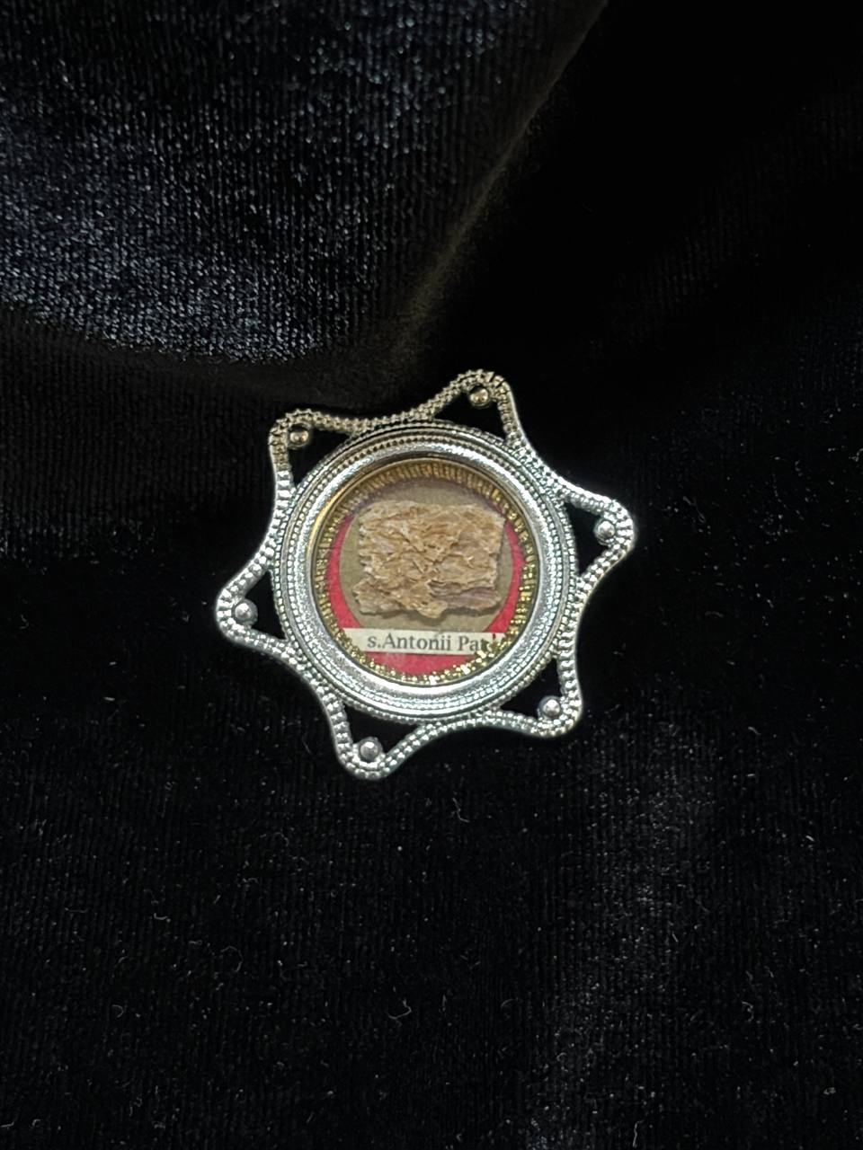 Saint Anthony of Padua relic in a silver star-shaped theca, label S. Antonii Pat., on black velvet