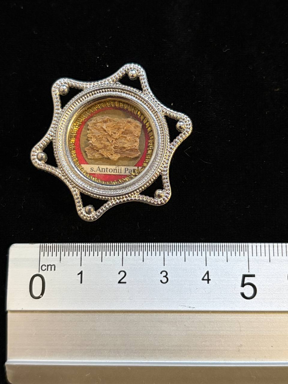 Saint Anthony of Padua relic star theca next to a ruler, about 4.5 cm across
