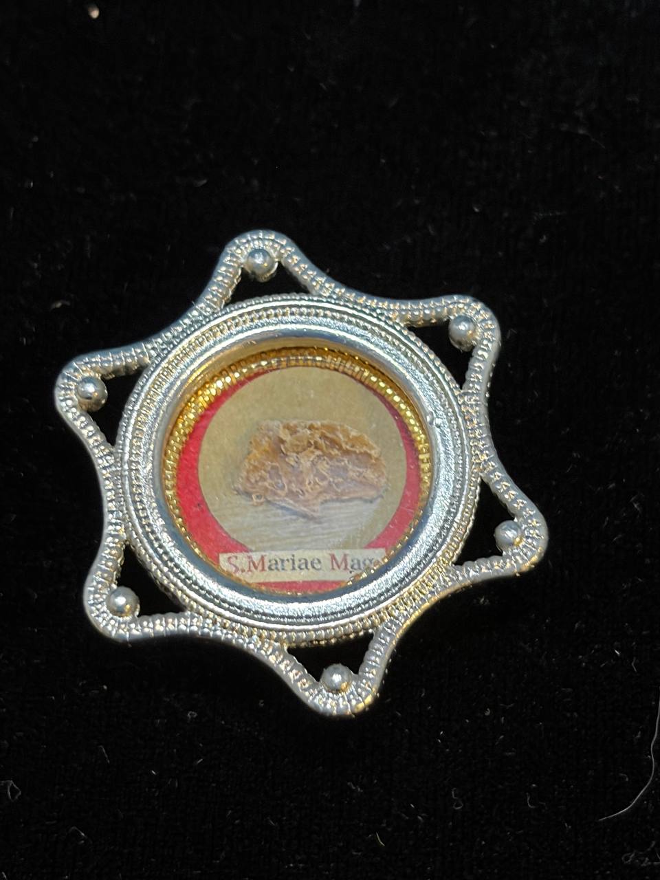 Saint Mary Magdalene relic in a silver star-shaped theca, label S. Mariae Magd., on black velvet