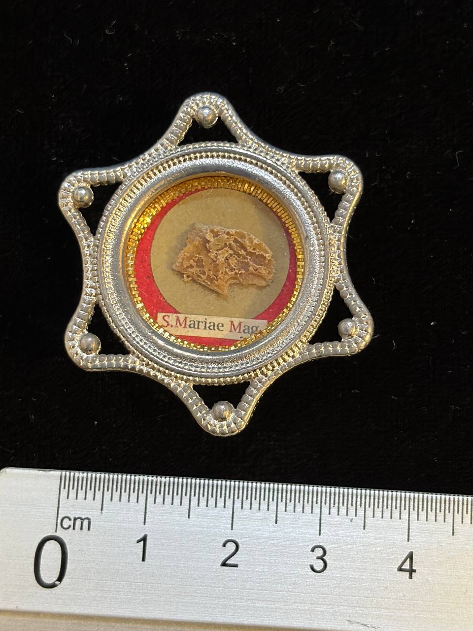 Saint Mary Magdalene relic star theca next to a ruler, about 4.5 cm across