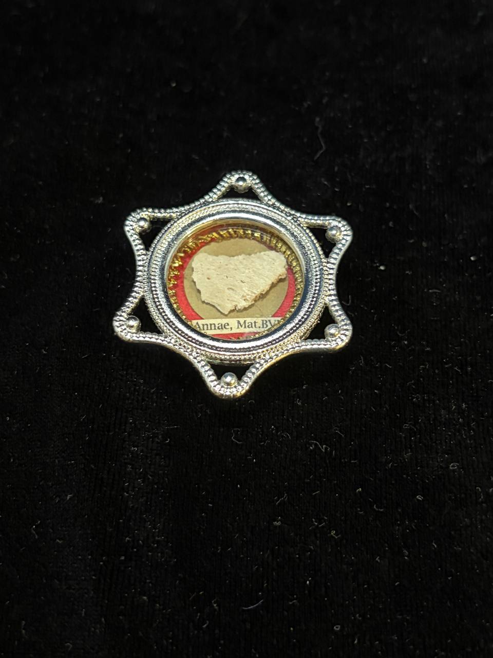 Saint Anne relic in a silver star-shaped theca, label S. Annae Mat. B.V.M., on black velvet