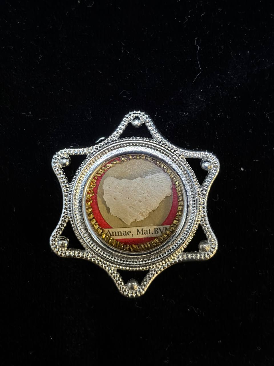 Saint Anne relic in a silver star-shaped theca, label S. Annae Mat. B.V.M., angled view