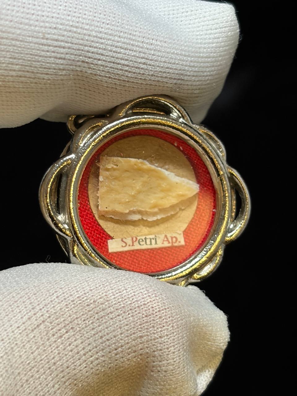 Saint Peter the Apostle relic in a silver quatrefoil theca, label S. Petri Ap., held in a white glove