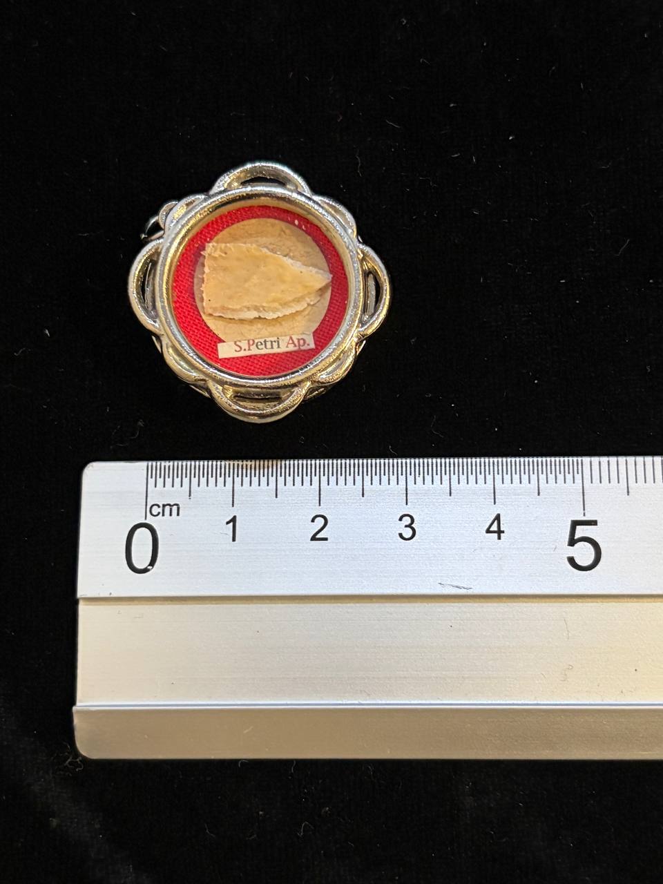Saint Peter relic theca next to a ruler, about 3.5 cm across