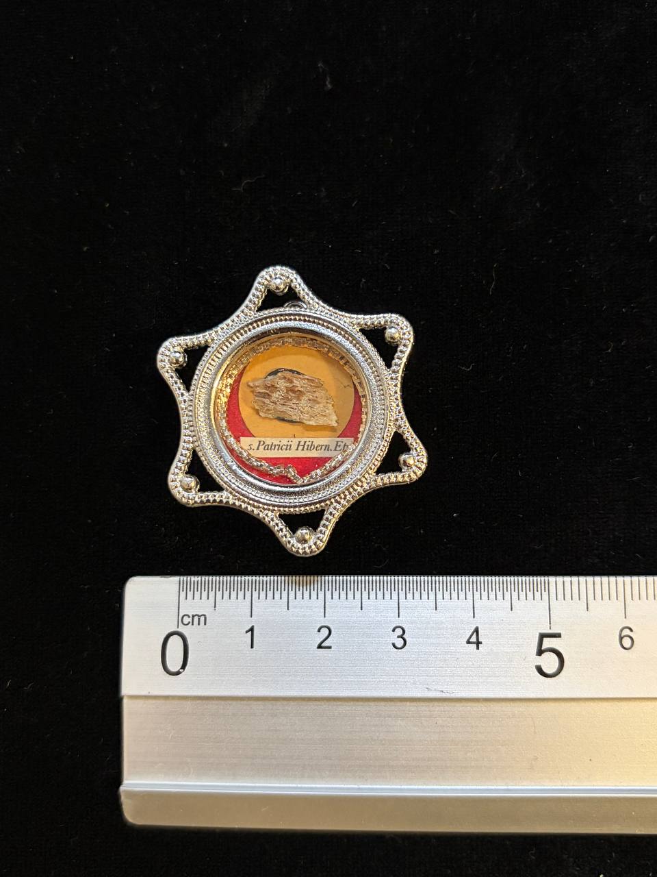 Saint Patrick relic star theca next to a ruler, about 4.5 cm across