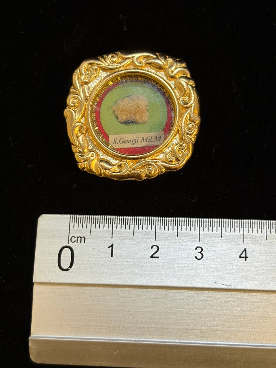Saint George relic theca next to a ruler, about 3.5 cm across