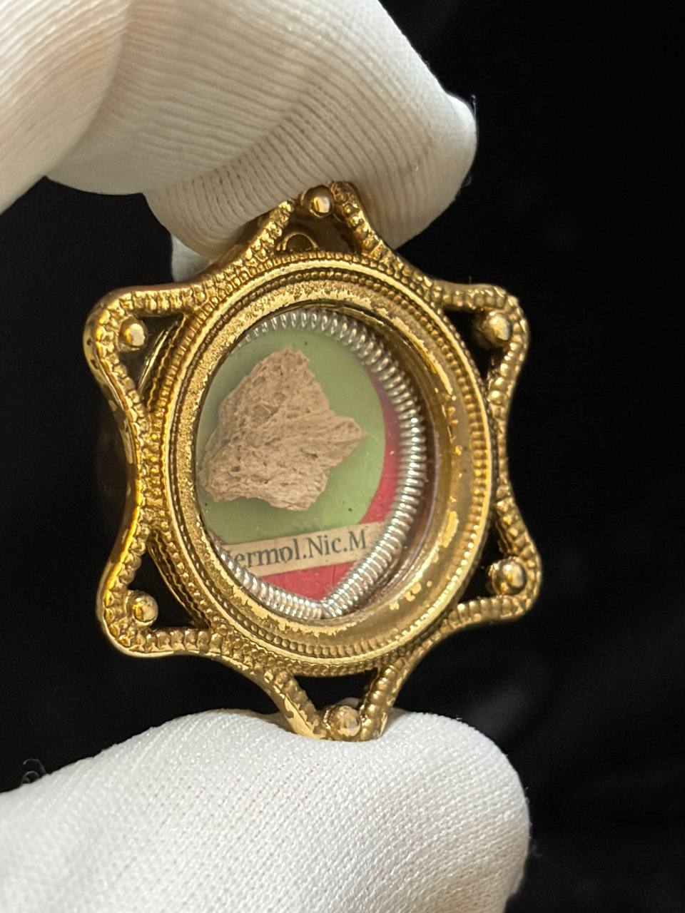 Saint Hermolaus relic theca shown upright in a white glove