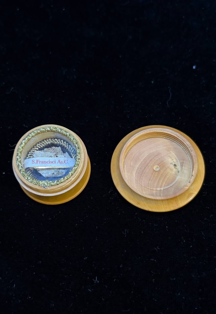 Wooden Saint Francis theca beside its open lid on black velvet