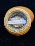 Saint Francis of Assisi relic in a round wooden theca with gilt trim, label S. Francisci As. C.