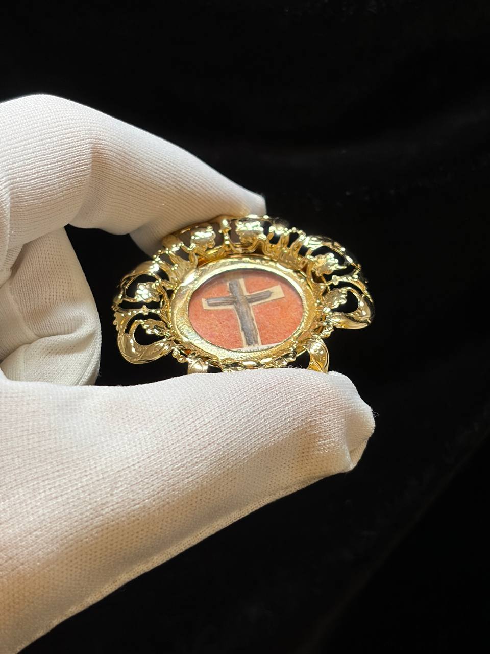 True Cross theca held between gloved fingers