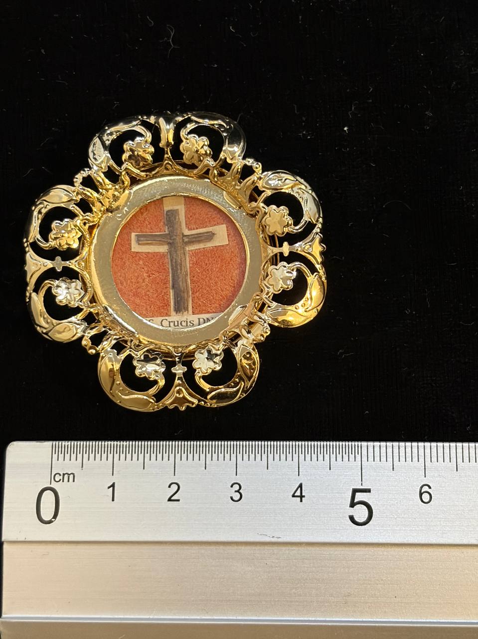 True Cross relic theca next to a ruler, about 5 cm across