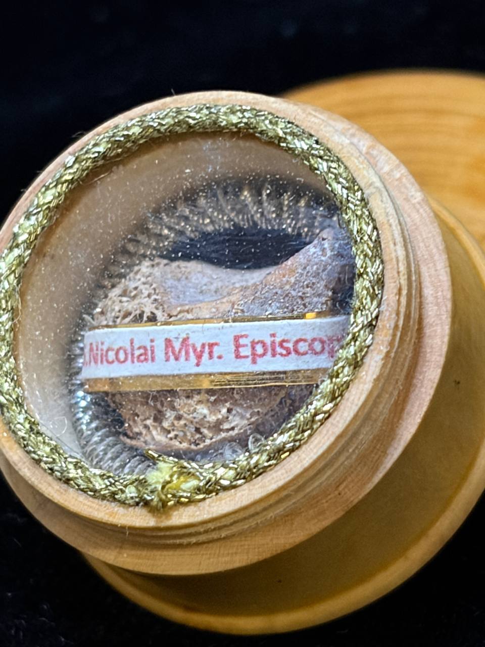 Close-up of the Saint Nicholas bone relic and label S. Nicolai Myr. Episcopi behind glass