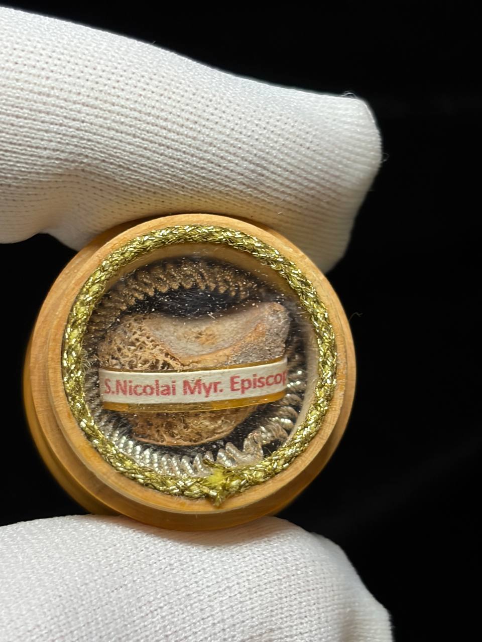 Close-up of the Saint Nicholas relic theca held in a white glove