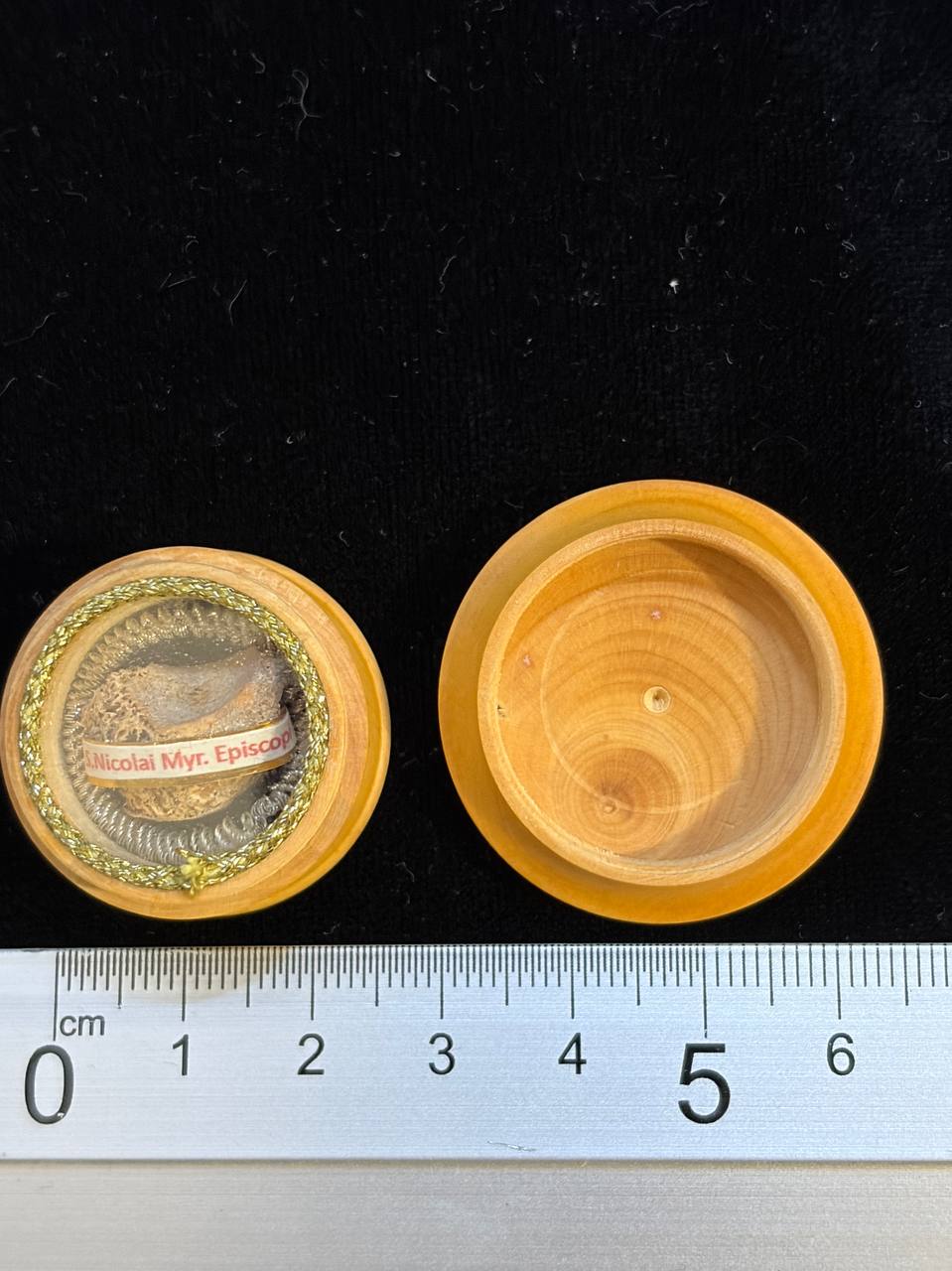 Saint Nicholas relic theca and lid next to a ruler, about 3 cm across