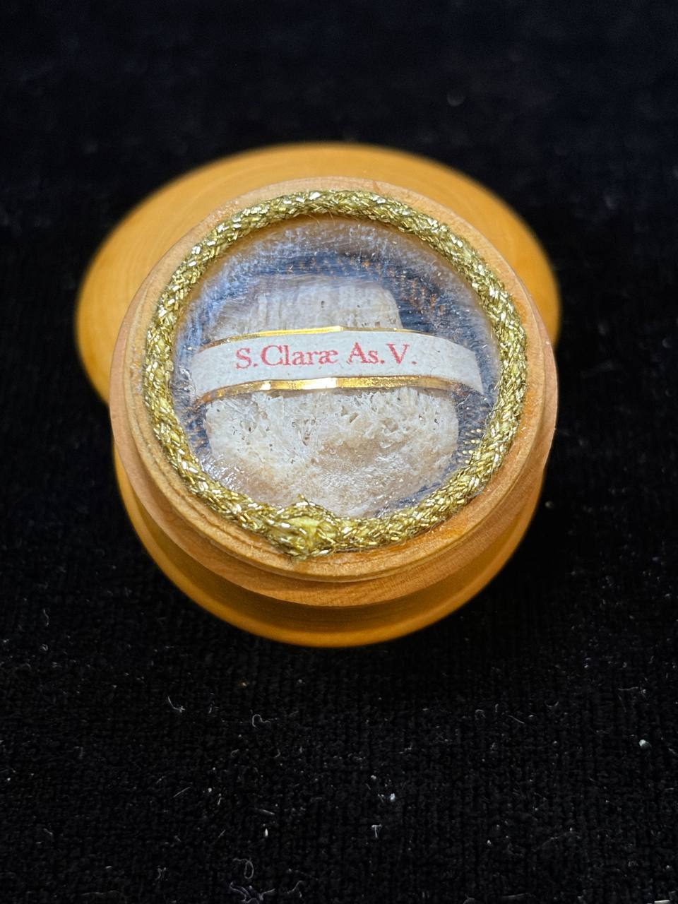 Saint Clare relic theca seen at an angle, relic fragment behind glass