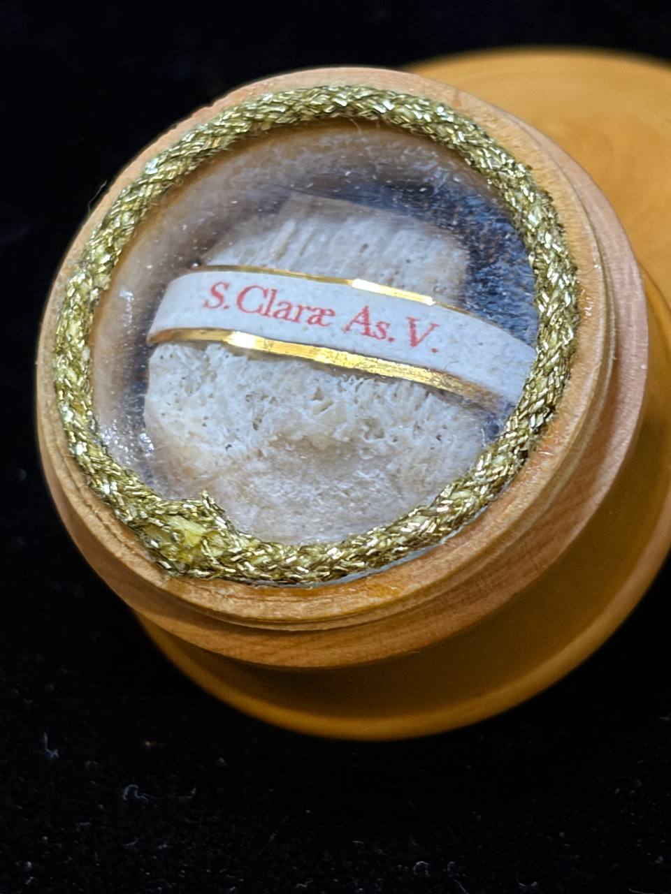 Close-up of the label S. Clarae As. V. and the relic fragment inside the Saint Clare theca