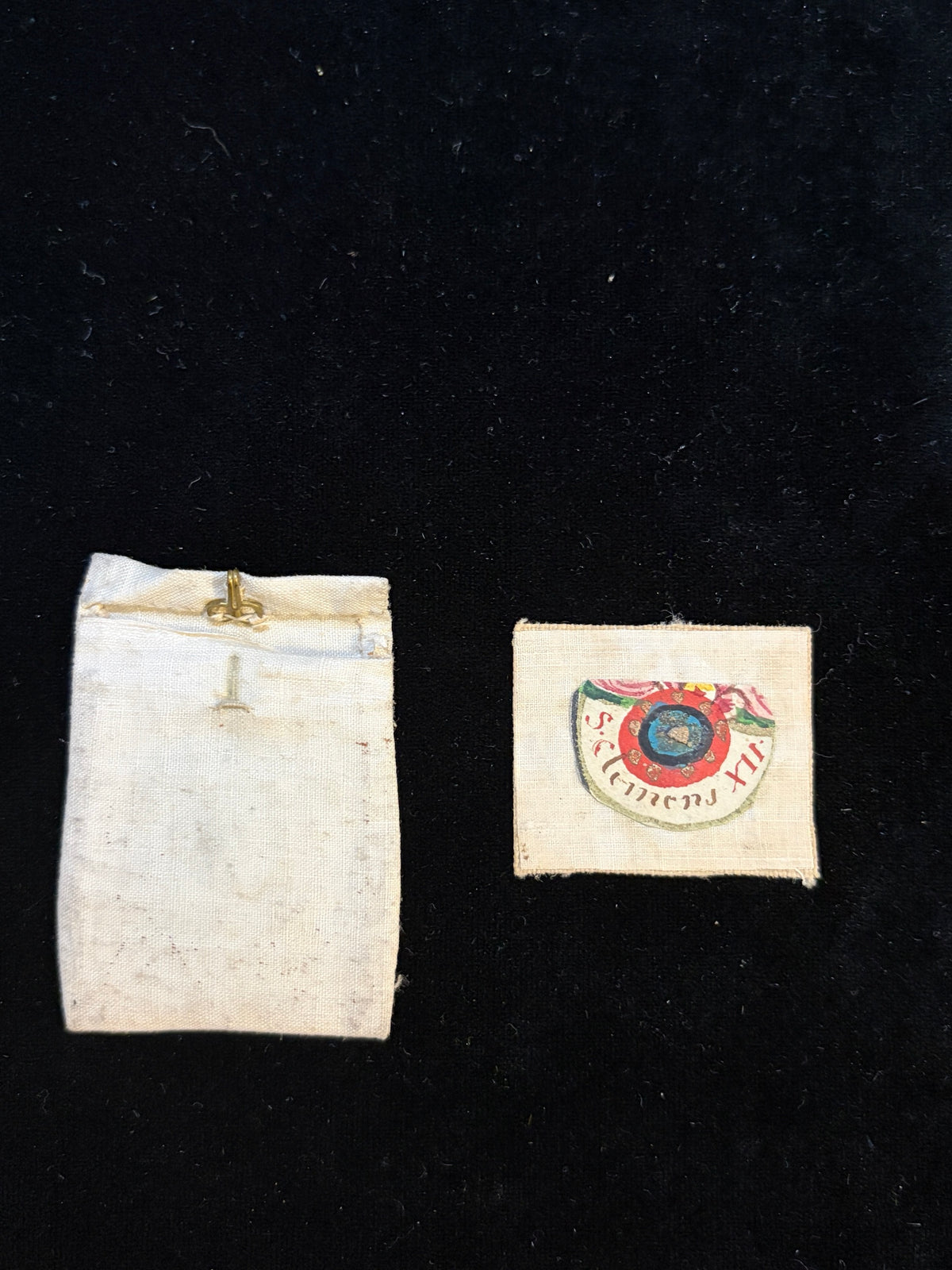 Antique linen relic bursa with hand-painted relic insert inscribed S. Clemens M., Saint Clement Martyr, with small bone fragment