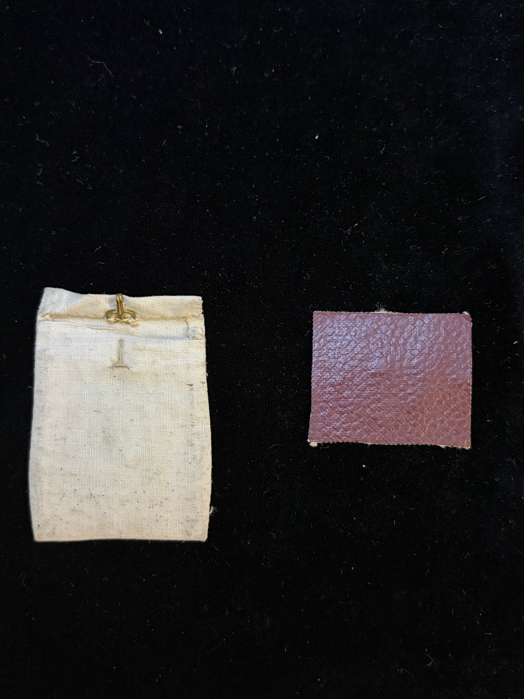 Burgundy leather back of the Saint Clement relic insert beside the linen relic pouch