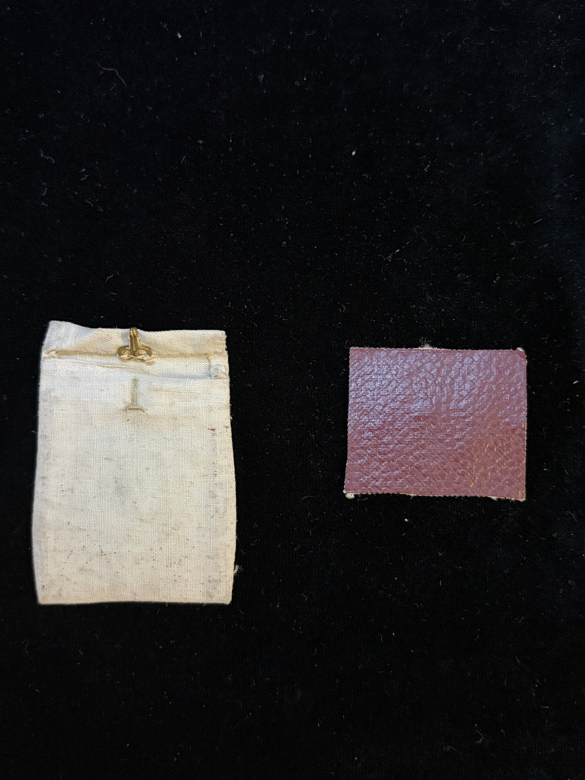 Burgundy leather back of the Saint Clement relic insert beside the linen relic pouch