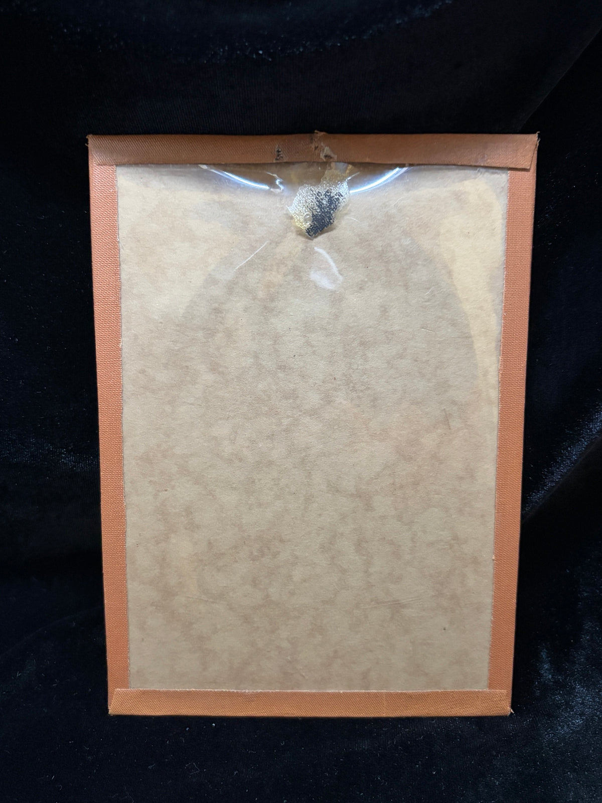 Back of the Saint Pius X contact relic mount with cloth-bound edges and cellophane cover